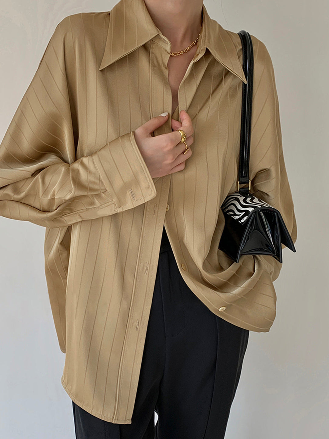 Model draagt oversized losse top blouse dames met streeppatroon casual zakelijk dunne stof zomer lente voorjaar shirt vrouwen beige