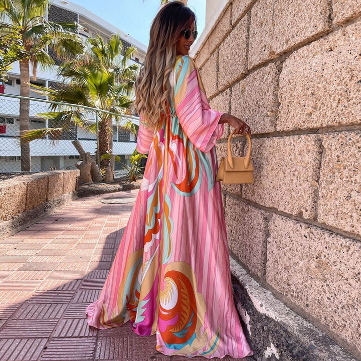 https://cdn.shopify.com/s/files/1/0768/1006/0099/files/CALORA_Abstract-Print-Maxi-Jurk-met-Ceintuur-en-V-Hals-in-Roze-3.jpg?v=1753729050