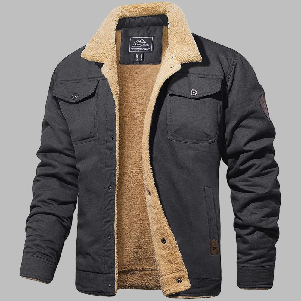 Donkergrijze heren bomberjack met beige sherpa voering, knoopsluiting en borstzakken. Winterjas, warme herenmode, stijlvolle buitenkleding.