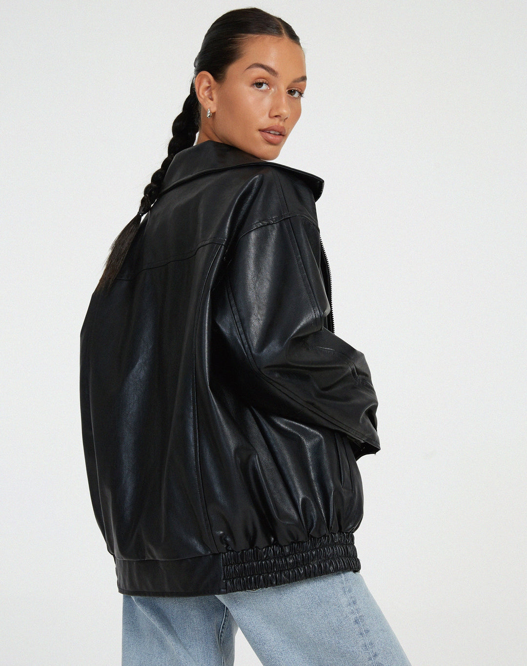 model draagt oversized losse leren jasje met rits sluiting rokje en hemd zwart leren biker jacket