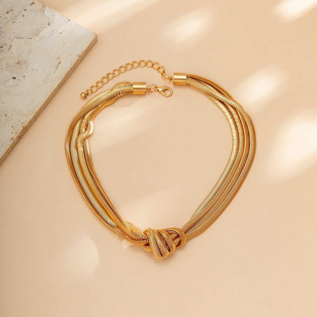 model draagt gewikkelde goude ketting met dikke knoop voor elegante chique dames sieraden