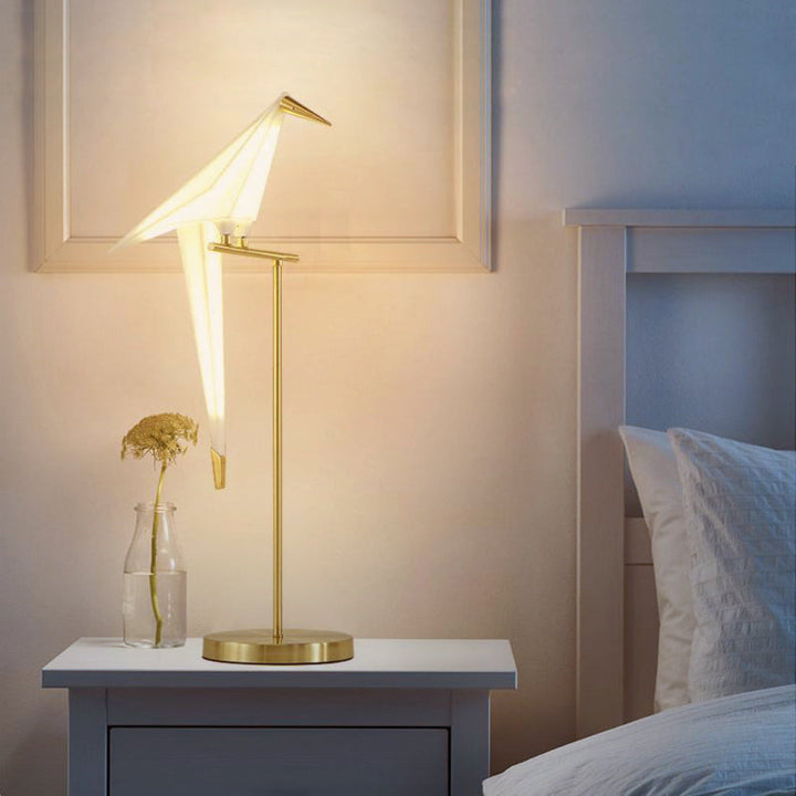 "Elegant wireless origami bird lamp with magnetic attachment emitting warm light; enhances home decor with artistic design."